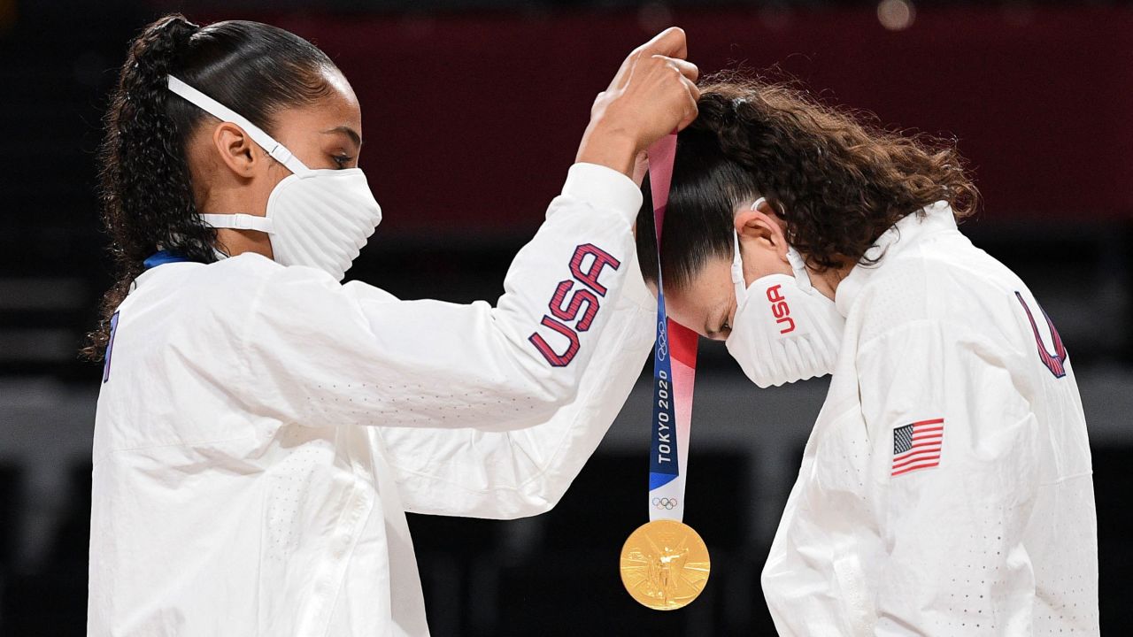 Team USA's Skylar Diggins (L) puts a gold medal on teammate Sue Bird during the medal ceremony for the women's basketball competition of the Tokyo 2020 Olympic Games on August 8.