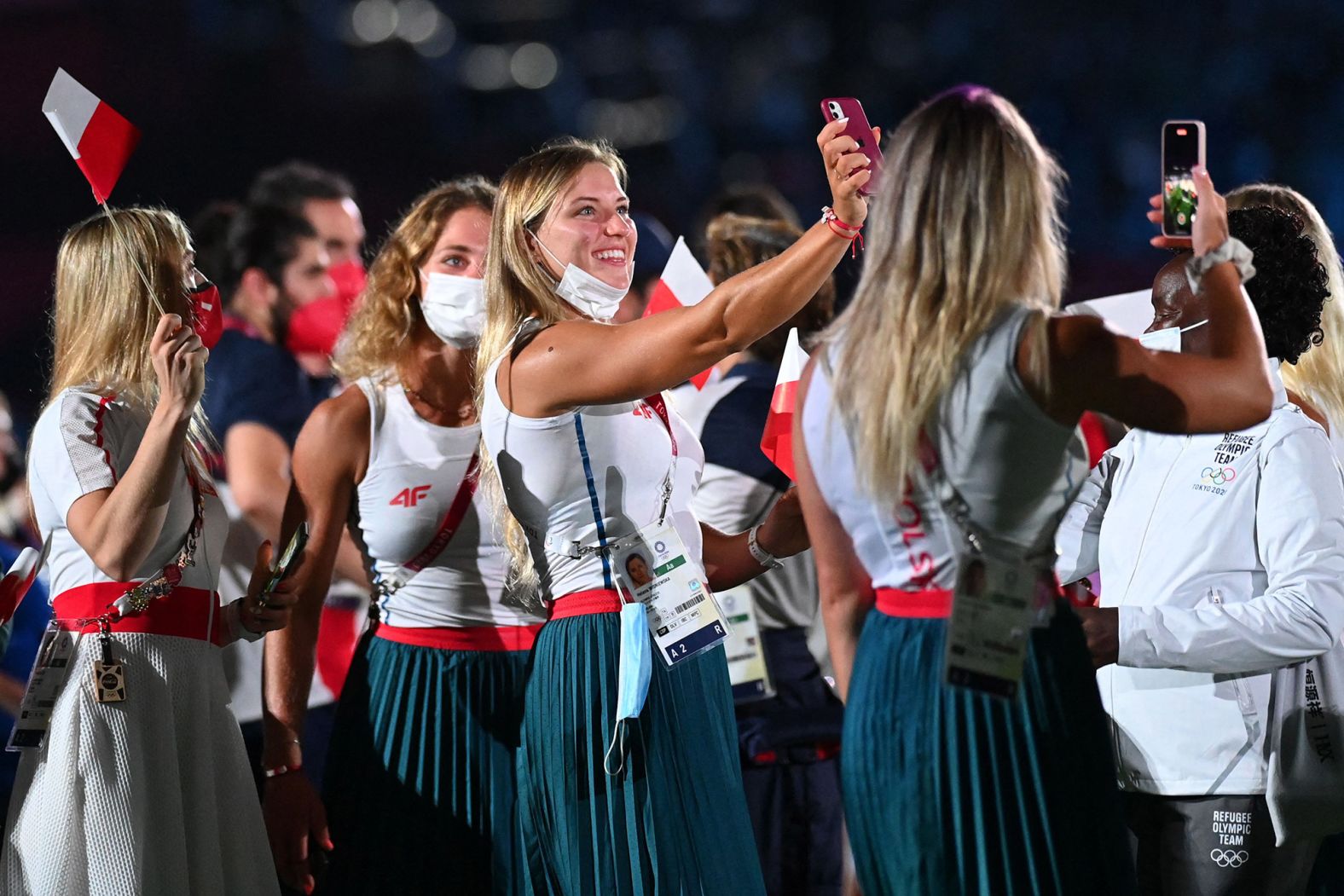 Polish athletes take pictures as they attend the closing ceremony.