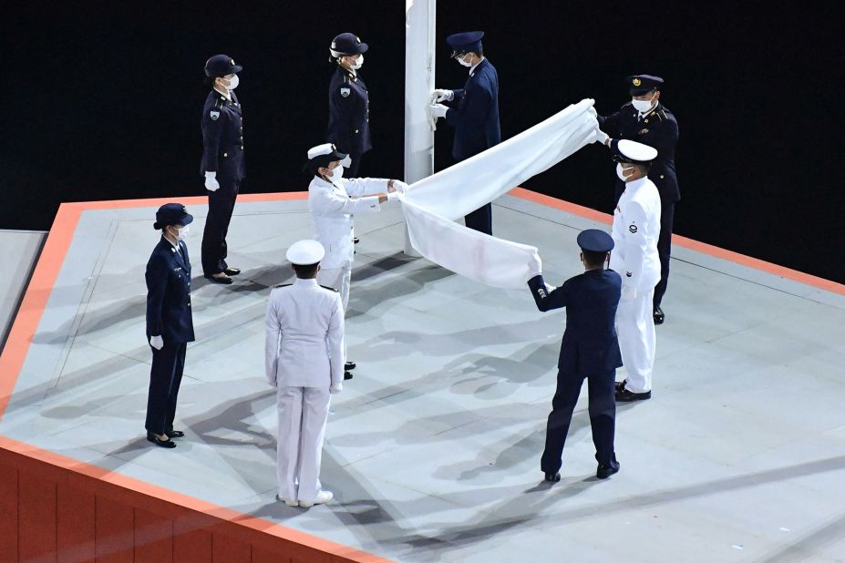 The Olympic flag is folded after being lowered during the closing ceremony.