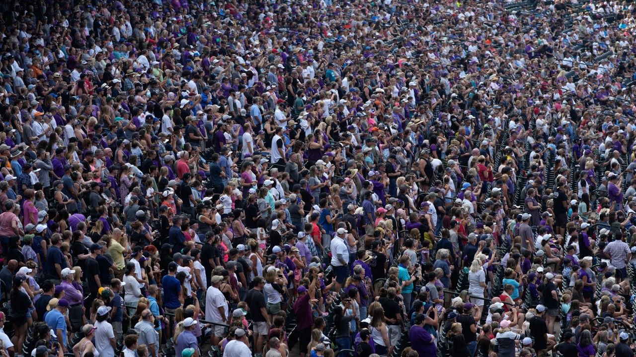 Fans  listen to a musical performance at Coors Field after the ninth inning of Sunday's game.