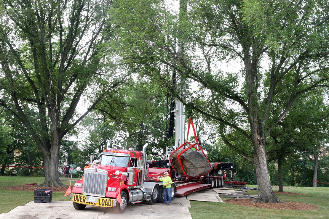 A crane operator slowly maneuvers Chamberlin Rock onto a flatbed trailer on campus on Friday.