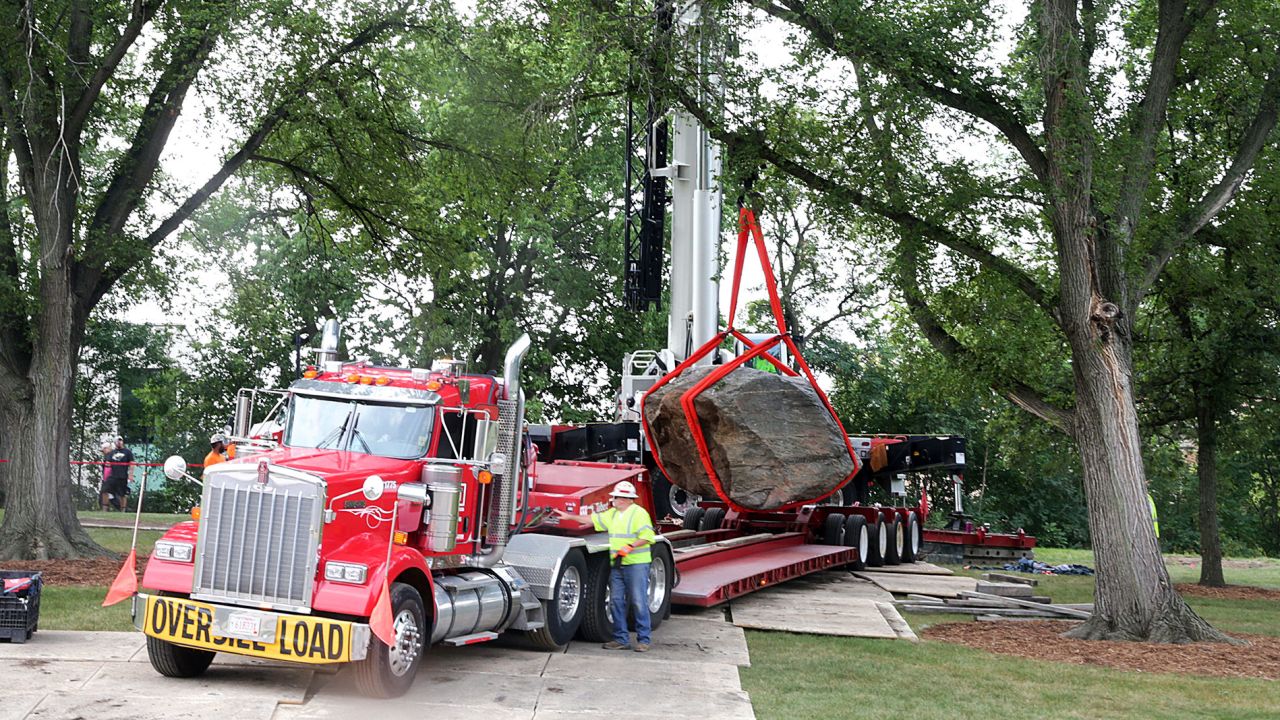A crane operator slowly maneuvers Chamberlin Rock onto a flatbed trailer on campus on Friday.