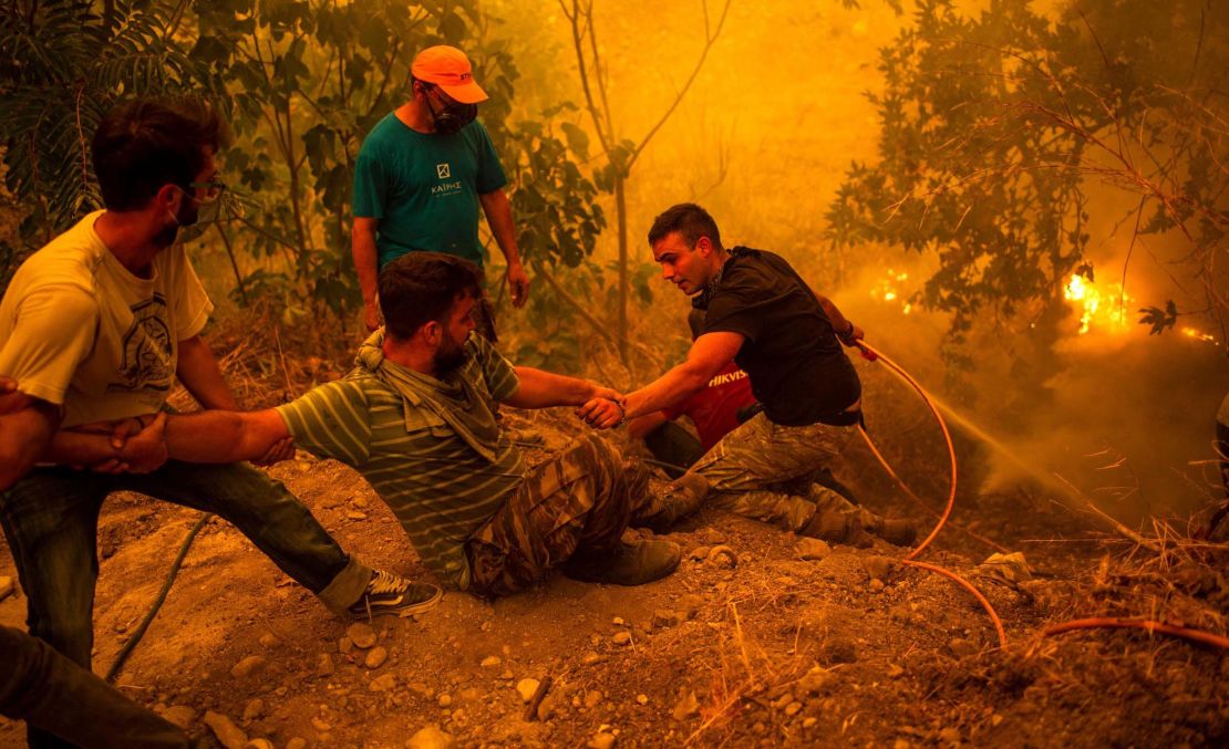 Local residents fight the wildfire in the village of Gouves on the Evia in Greece.