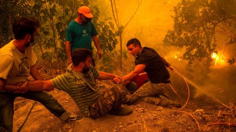 Local residents fight the wildfire in the village of Gouves on the Evia in Greece.