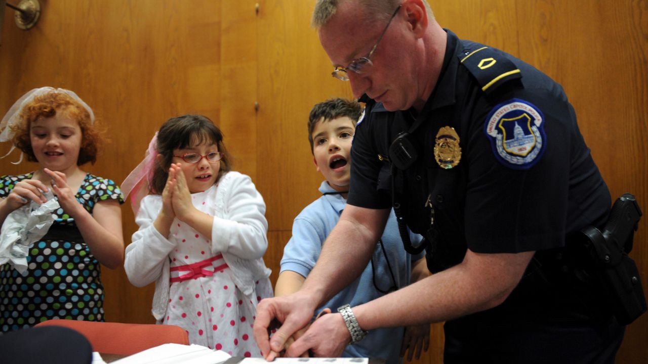 Capitol Police Officer Howard Liebengood fingerprints a child during "Kid Safety Day," held in Washington DC, in April 2008. Liebengood died by suicide after the US Capitol riot in January 2021.