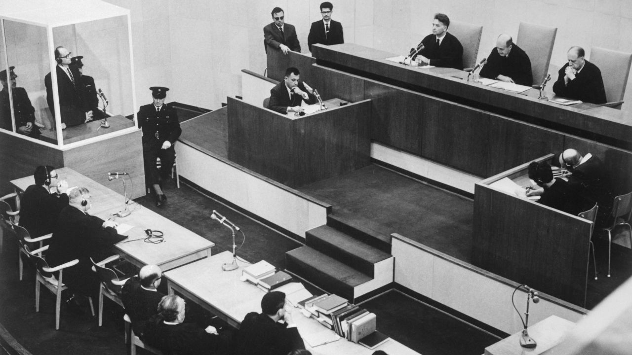 Adolf Eichmann listens in the prisoner's dock at the left, as presiding Judge Moishe Landau gives the verdict at the conclusion of his trial.