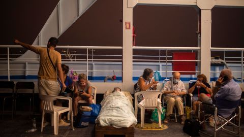 Elderly people are seen on chairs and makeshift bed onboard a ferry at the port of the village of Pefki, during a wildfire at Pefki village on Evia.