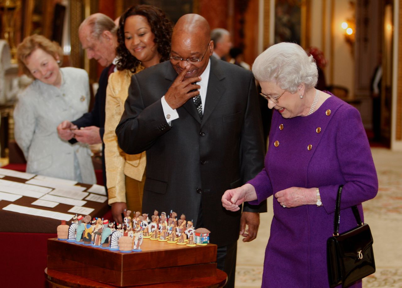 Zuma looks at a chess set with Britain's Queen Elizabeth II during his state visit in 2010. The chess set had been given to the Queen by Nelson Mandela in 1996.