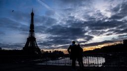 A couple look at the Eiffel Tower from the Debilly footbridge over the river Seine, at sunset on January 17, 2021, in Paris. (Photo by Martin BUREAU / AFP) (Photo by MARTIN BUREAU/AFP via Getty Images)