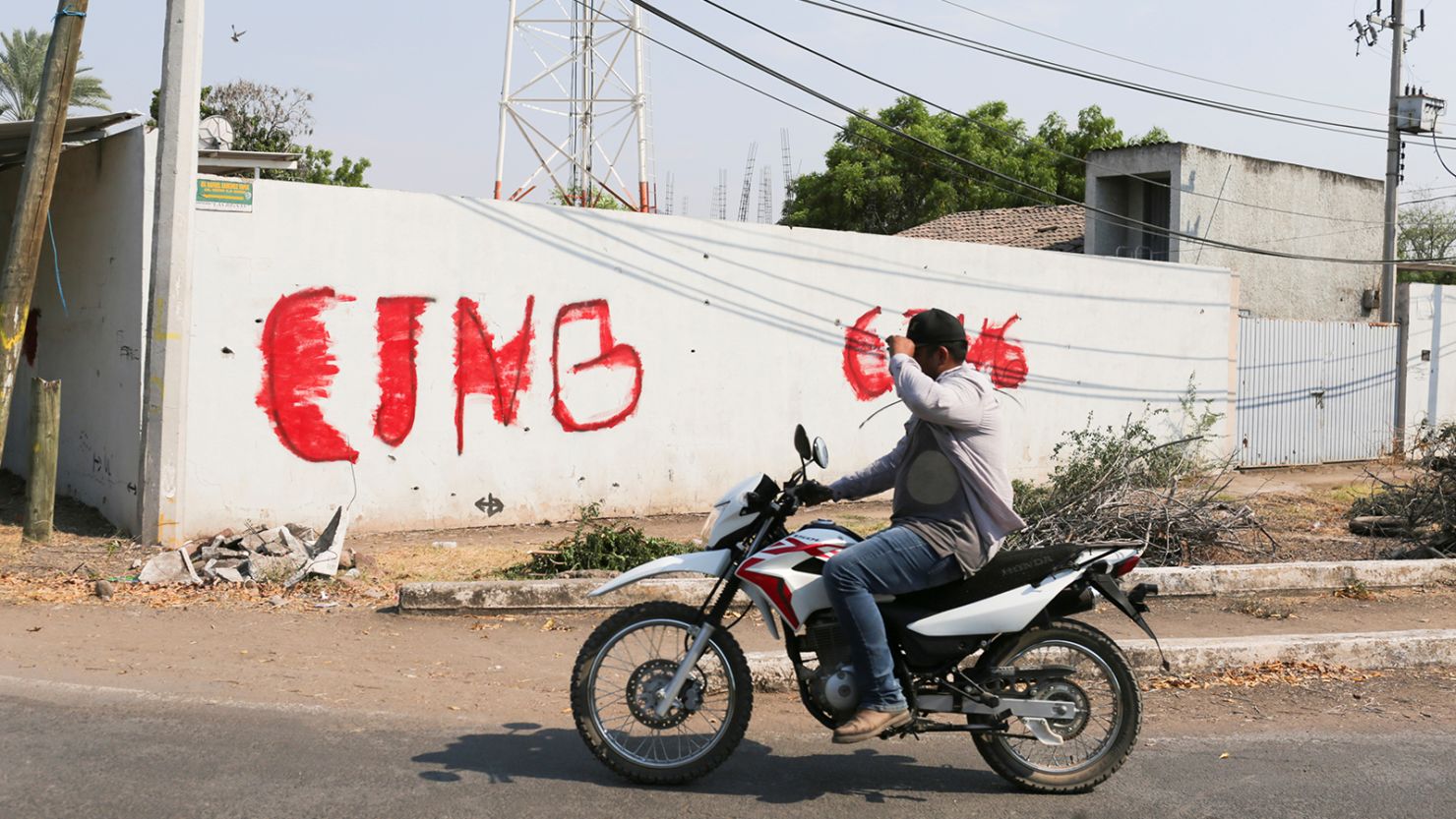 A motorist passes by a wall with a graffiti of the Jalisco New Generation Cartel (CJNG) in Michoacan state, Mexico, on April 23.