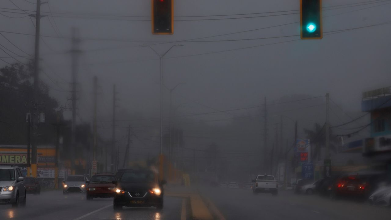 Vehicles drive in heavy rain in Vega Alta, Puerto Rico, on August 10, 2021, ahead of Tropical Storm Fred.