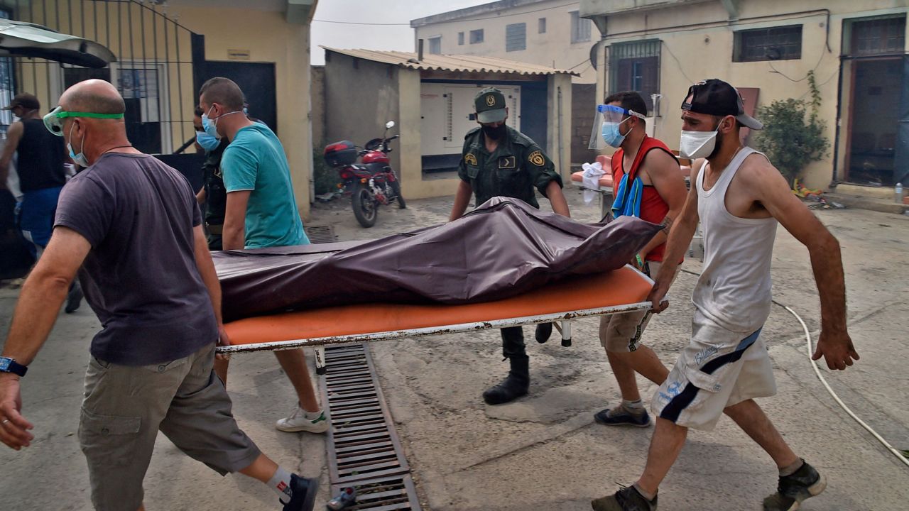 Medics carry away the body of a man during a wildfire in Tizi Ouzou, one of the most populous cities in Algeria's Kabylie region, on August 10.