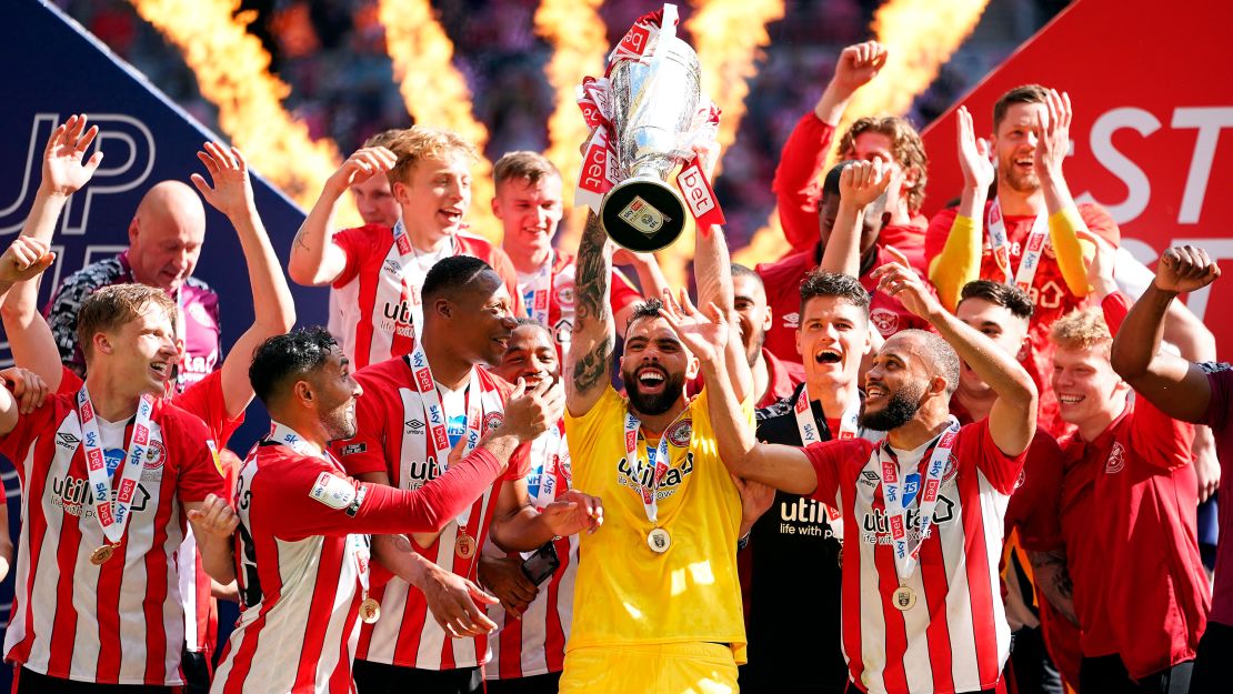 Brentford goalkeeper David Raya Martin lifts the trophy as they celebrate promotion to the Premier League after winning the Championship playoff final at Wembley Stadium.