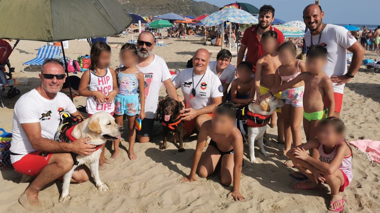 Rescue workers from the Italian rescue dog school SICS are seen with the rescued children in Sperlonga on August 8 2021. CNN has blurred portions of this image.