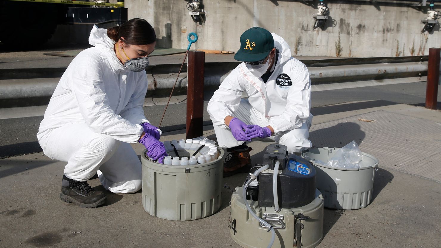 OAKLAND, CA - JULY 14: Gabriela Esparza and Zach Wu, wastewater control inspectors with EBMUD, cap 24 separate bottles while retrieving collection equipment and the samples in Oakland, Calif. on Tuesday, July 14, 2020. The samples are sent to a number of labs to analyze for any detection of the COVID-19 coronavirus in the sewage system. (Paul Chinn/The San Francisco Chronicle via Getty Images)