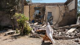 A woman walks in front of a damaged house which was shelled as federal-aligned forces entered the city, in Wukro, north of Mekele, on March 1, 2021. - Every phase of the four-month-old conflict in Tigray has brought suffering to Wukro, a fast-growing transport hub once best-known for its religious and archaeological sites. Ahead of federal forces' arrival in late November 2020, heavy shelling levelled homes and businesses and sent plumes of dust and smoke rising above near-deserted streets. Since then the town has been heavily patrolled by soldiers, Eritreans at first, now mostly Ethiopians, whose abuses fuel a steady flow of civilian casualties and stoke anger with Nobel Peace Prize-winner Abiy. (Photo by EDUARDO SOTERAS / AFP) (Photo by EDUARDO SOTERAS/AFP via Getty Images)