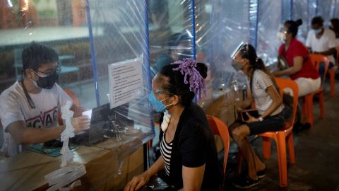 People are screened to get the Moderna Covid-19 vaccine in a school turned vaccination site that operates 24/7, in Manila, Philippines, on August 10.