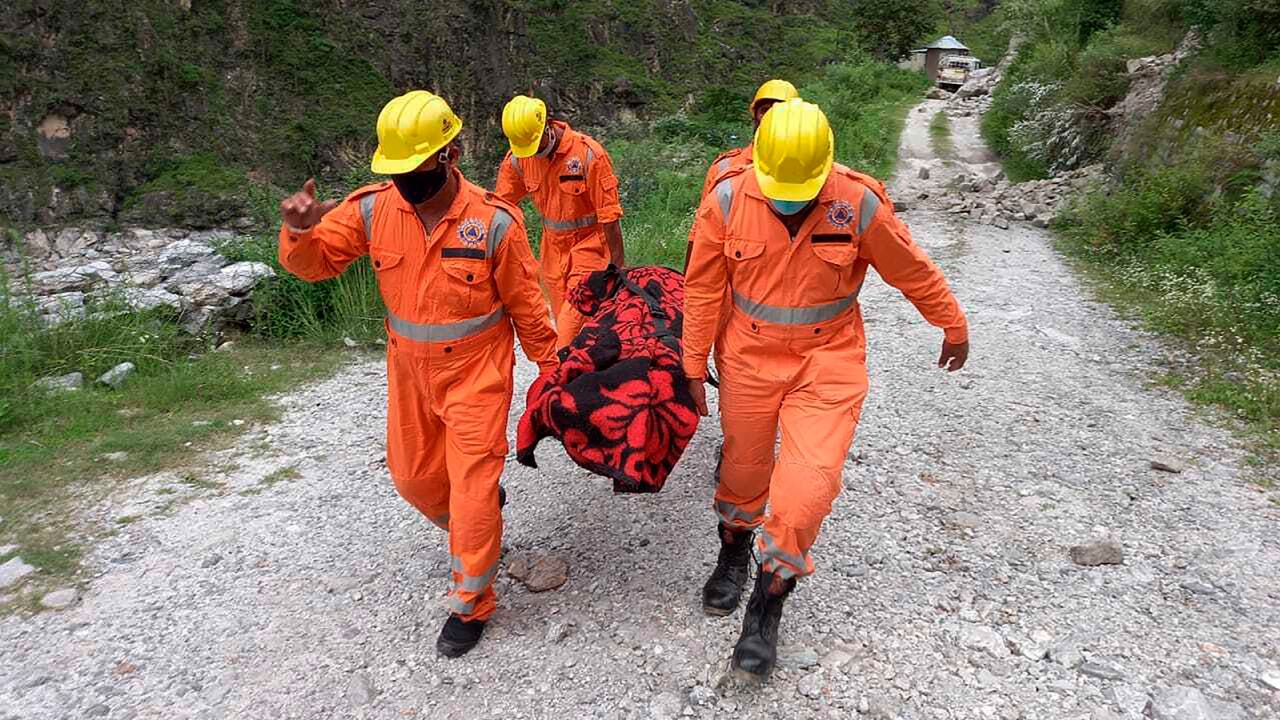 Soldiers carrying the body of a victim from the site of a landslide in Himachal Pradesh, India, on August 11.