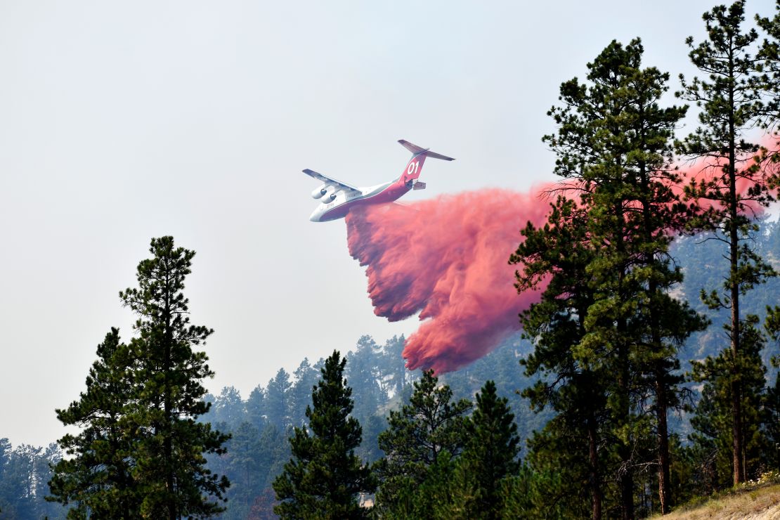 An aircraft drops fire retardant to slow the spread of the Richard Spring fire on August 11, 2021.