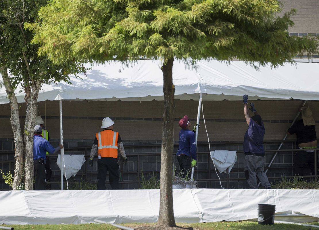 A construction crew works to set up tents that hospital officials plan to use with an overflow of Covid-19 patients outside of Lyndon B. Johnson Hospital, Monday, Aug. 9, 2021, in Houston.