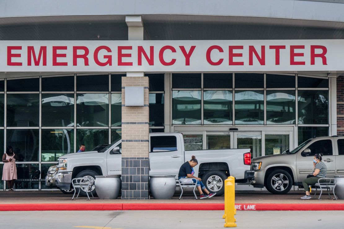 People wait outside of the Lyndon B. Johnson Hospital on August 10, 2021 in Houston. The hospital has set up medical tents in preparation for an overflow of patients being treated for the Covid-19 Delta variant. 