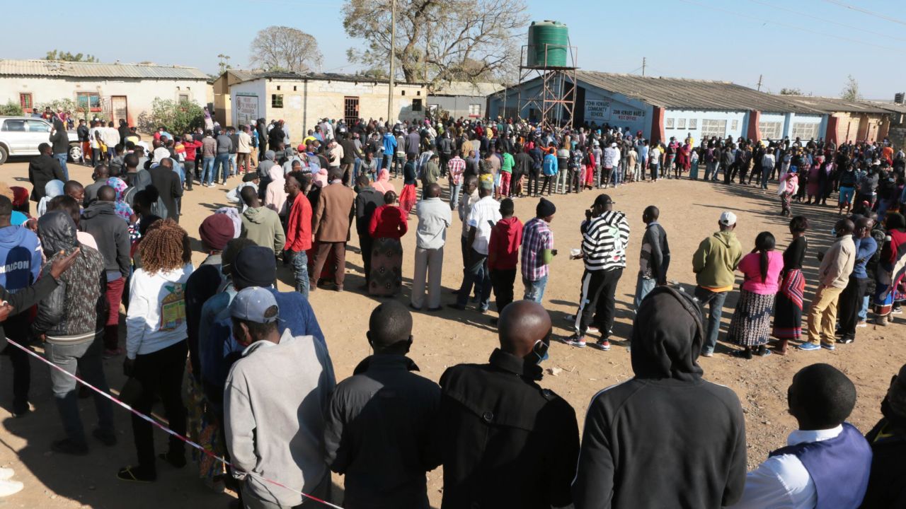 People wait in a long queue at a polling station in Lusaka, Zambia on Thursday.
