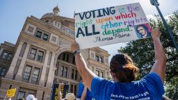 People display signs during the Georgetown to Austin March for Democracy rally on July 31, 2021 in Austin, Texas. 