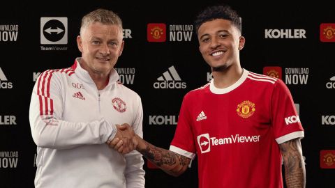 Jadon Sancho shakes hands with Manchester United manager Ole Gunnar Solskjaer after signing with the club.