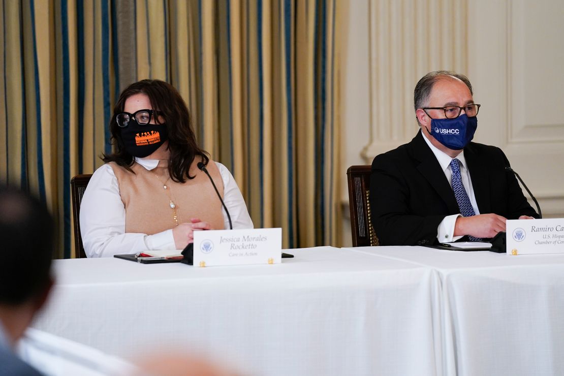 Jess Morales Rocketto, civic engagement director of the National Domestic Workers Alliance, (left), and Ramiro Cavazos, president and CEO of the US Hispanic Chamber of Commerce, listen as President Joe Biden speaks during a meeting with Latino leaders in the White House on August 3, 2021.