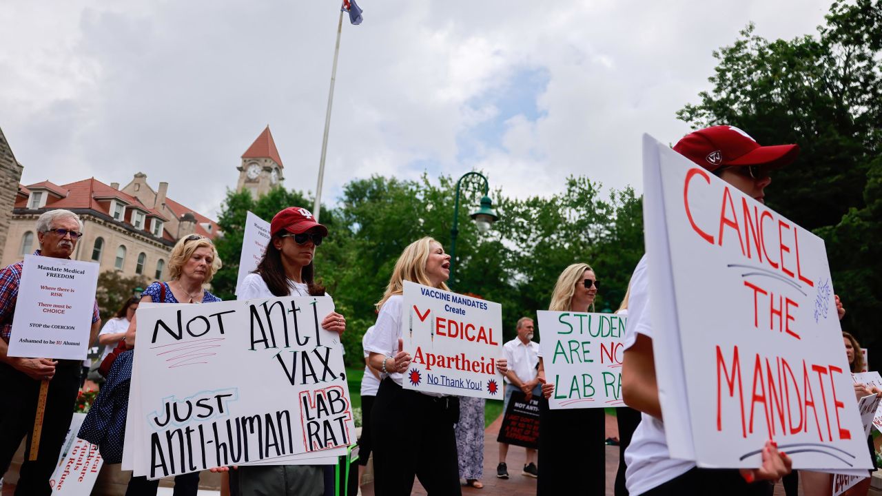 Protesters hold placards during a June 2021 demonstration at Indiana University's Sample Gates to protest mandatory Covid vaccinations.