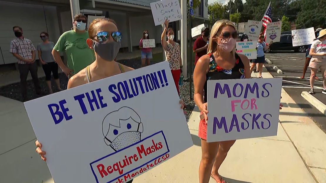 Parents hold up signs at the Marietta protest on Thursday.