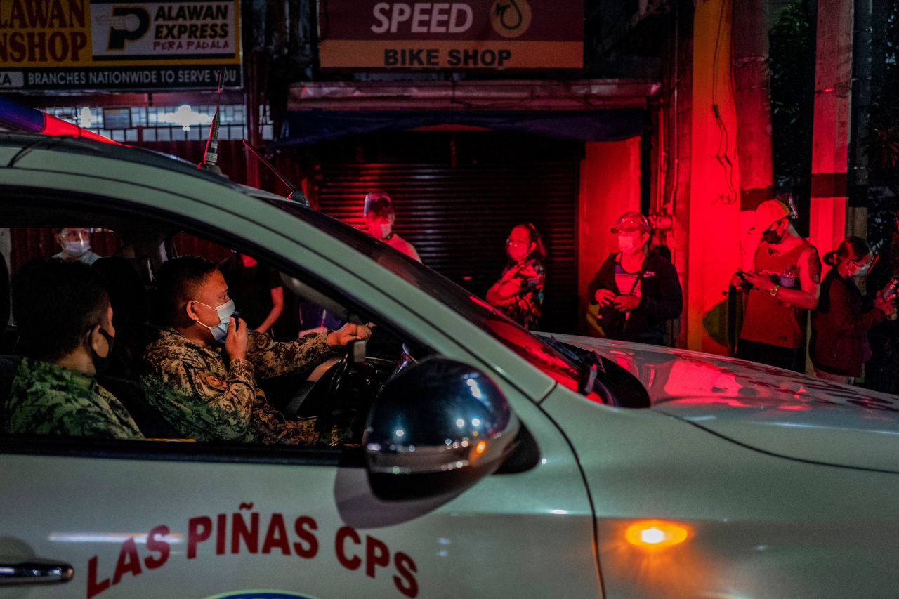 A police officer reminds people to observe social distancing as they line up for a Covid-19 vaccine in Las Piñas, Philippines, on Sunday, August 8. Coronavirus cases <a href="https://www.cnn.com/2021/08/06/asia/manila-philippines-vaccine-lockdown-intl-hnk/index.html" target="_blank">have been rising in the Philippines since July,</a> driven by the highly infectious Delta variant.
