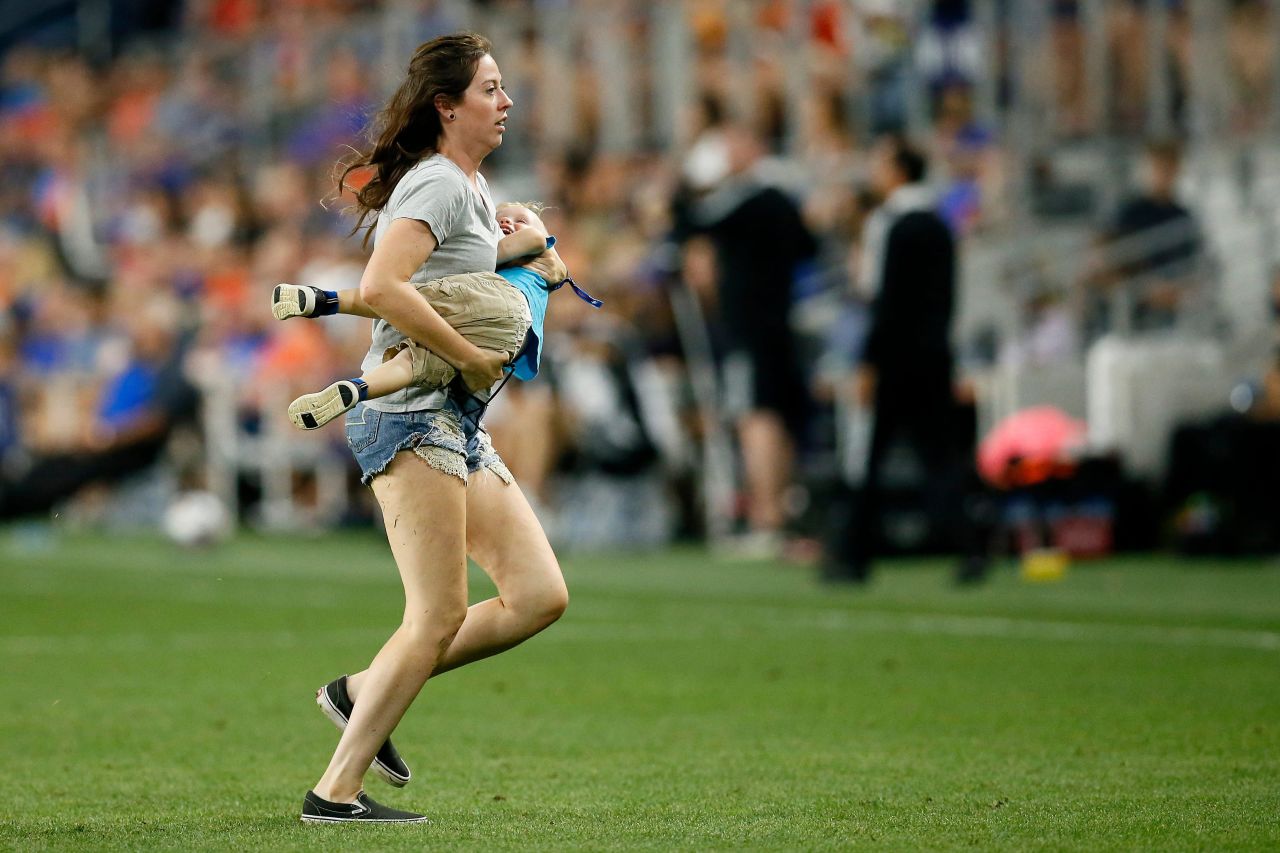 Morgan Tucker carries her 2-year-old son, Zaydek Carpenter, off the field during a Major League Soccer game in Cincinnati on Saturday, August 7. Tucker had to chase down Zaydek after he slipped away and ran onto the field during play.