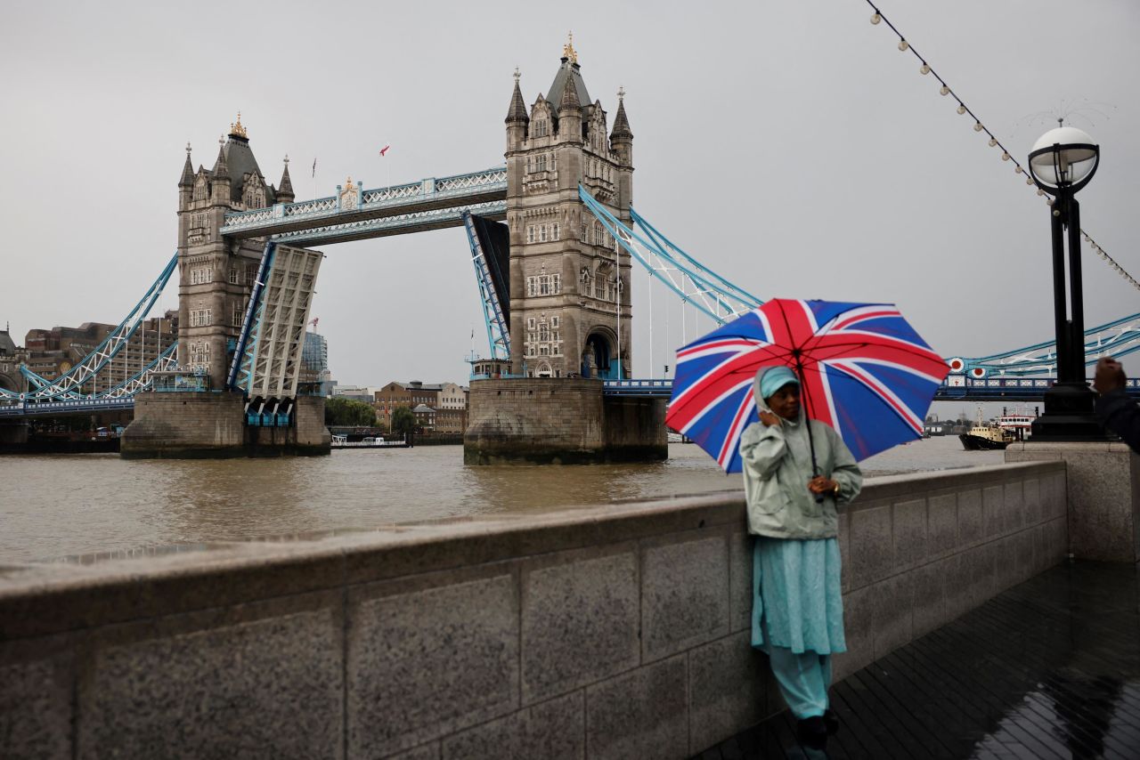 A pedestrian poses for a picture by London's Tower Bridge as it was <a href="https://www.cnn.com/travel/article/london-tower-bridge-stuck-scli-intl-gbr/index.html" target="_blank">stuck in an open position</a> due to a "technical failure" on Monday, August 9.