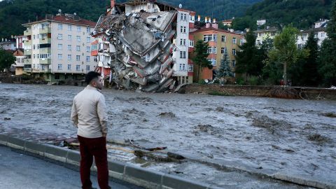 A man looks on as flood waters sweep by in Bozkurt town of Kastamonu province of Turkey on Thursday.