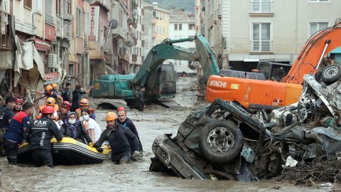 A rescue team evacuates residents in a boat in a residential area affected by heavy floods.