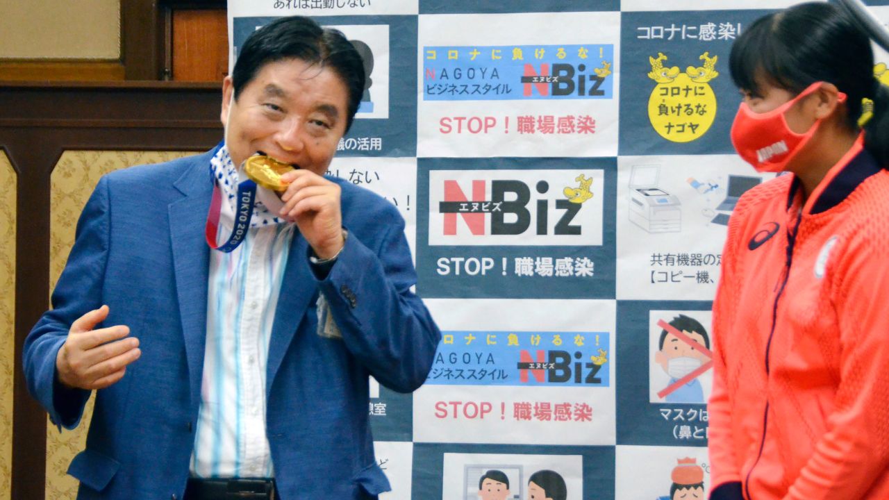 Nagoya Mayor Takashi Kawamura bites the Olympic gold medal of Miu Goto. 