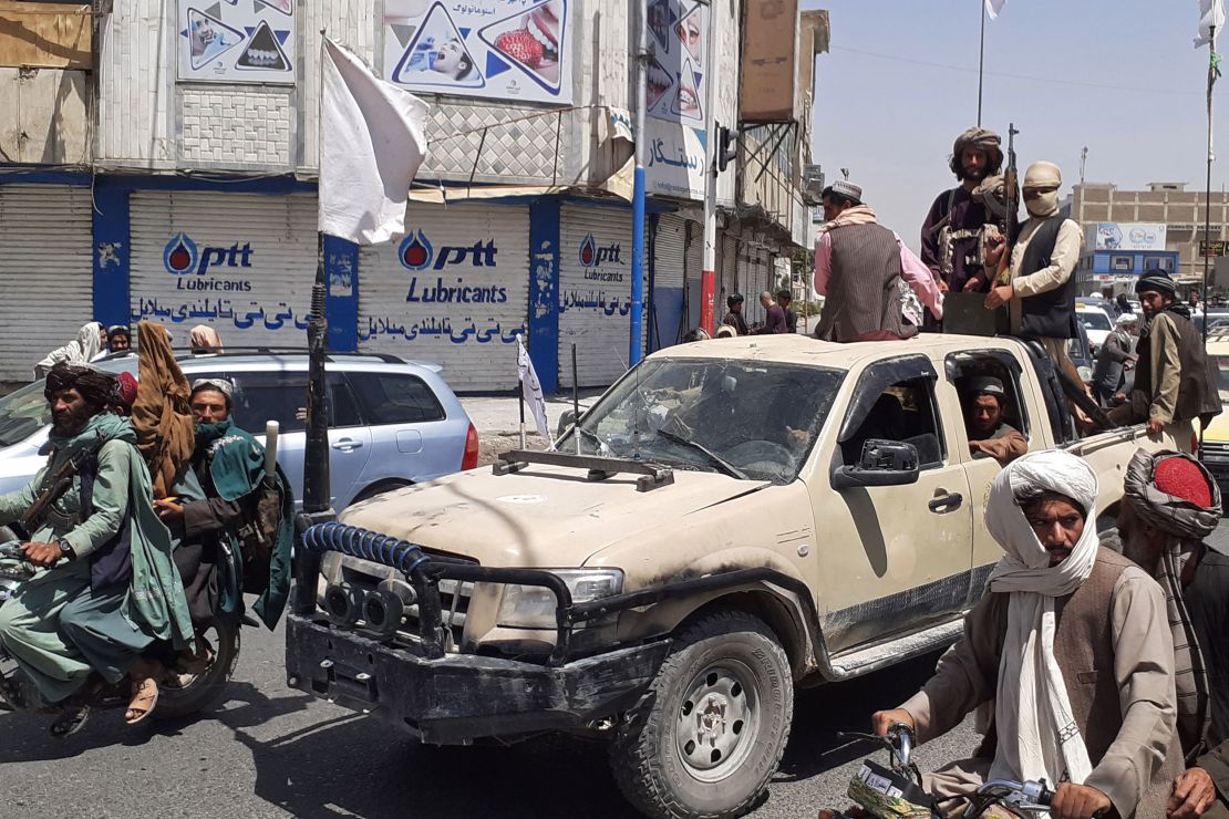 Taliban fighters drive an Afghan National Army (ANA) vehicle through a street in Kandahar on August 13, 2021.