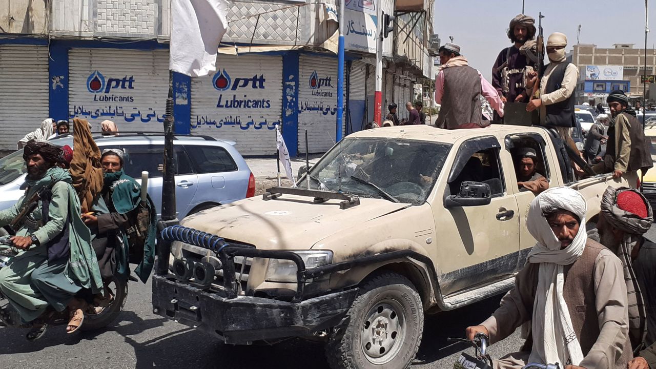 Taliban fighters drive an Afghan National Army (ANA) vehicle through a street in Kandahar on August 13, 2021.