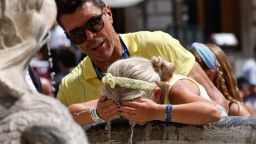 A child refreshes herself at a fountain in downtown Rome, Wednesday, Aug. 11, 2021. The ongoing heatwave will last up until the weekend with temperatures expected to reach over 40 degrees Celsius in many parts of Italy. (AP Photo/Riccardo De Luca)