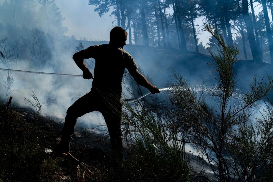 A man works to douse a fire in Montalto, Italy, on August 12.