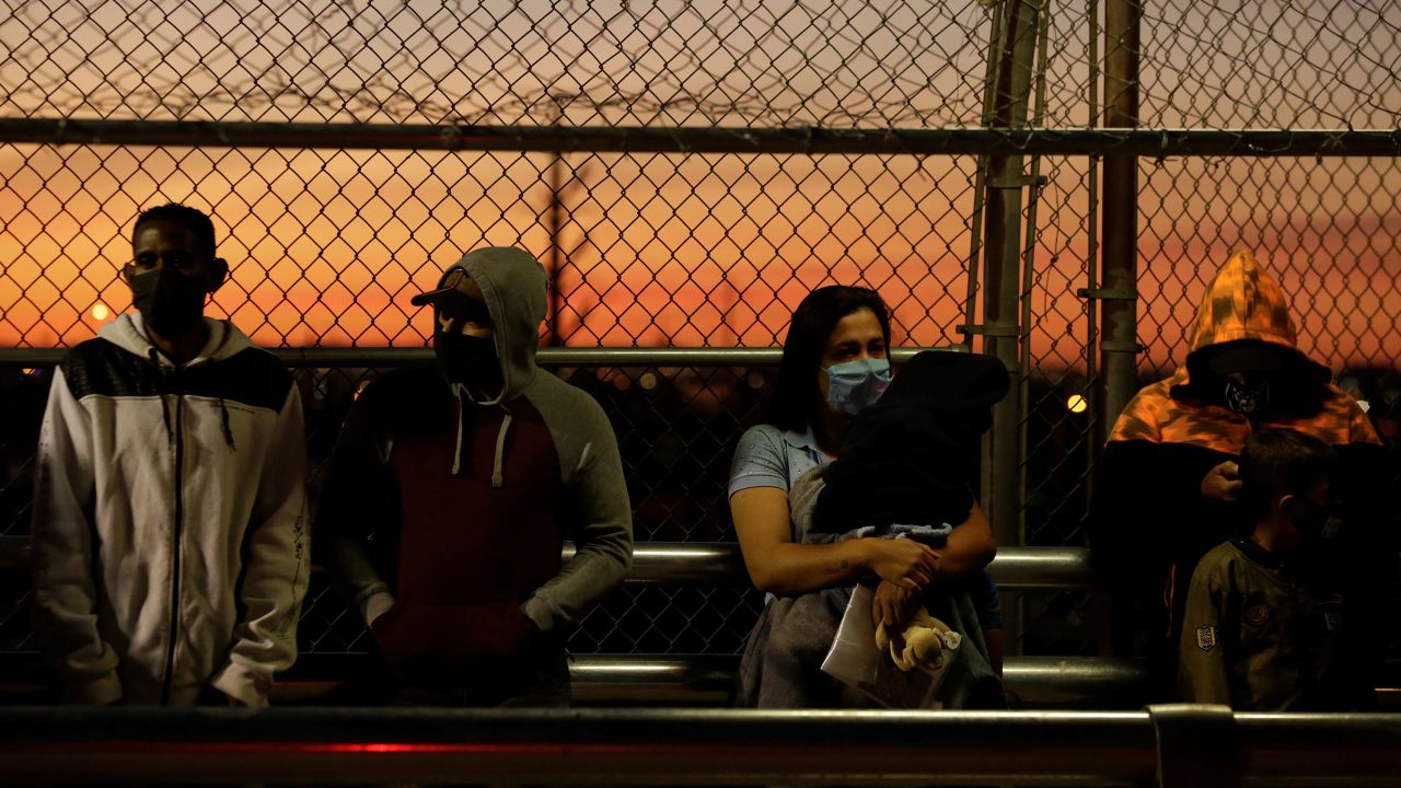 In this April 21, 2020, file photo, migrants in the "remain in Mexico" program queue at the Paso del Norte border bridge to reschedule their immigration hearings amid the coronavirus outbreak, in Ciudad Juarez, Mexico.