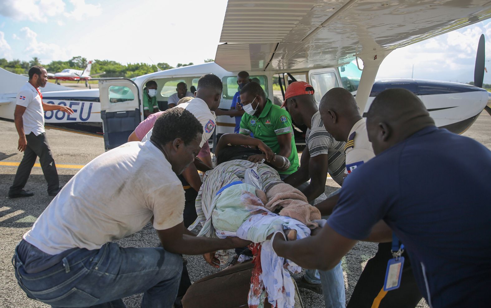 An injured woman is transferred to a plane to be flown to Port-au-Prince, Haiti, on August 14.