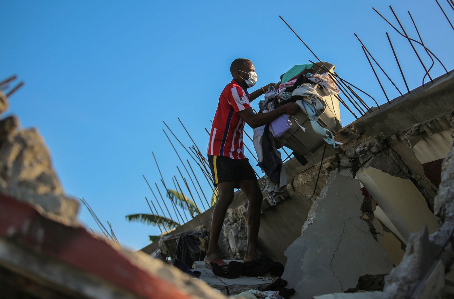 A man recovers belongings from his Les Cayes home, which was destroyed by the earthquake.