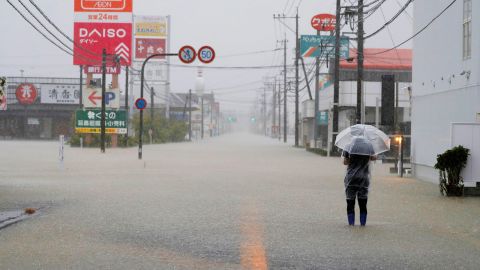 A man walks on a road flooded by heavy rain in southwestern Japan's Saga Prefecture on Saturday.