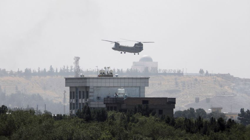 A U.S. Chinook helicopter flies near the U.S. Embassy in Kabul, Afghanistan, Sunday, Aug. 15, 2021. Helicopters are landing at the U.S. Embassy in Kabul as diplomatic vehicles leave the compound amid the Taliban advanced on the Afghan capital. (AP Photo/Rahmat Gul)