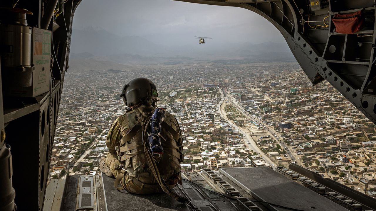 An American soldier sits on a CH-47 Chinook helicopter flying over Kabul on May 2, 2021.
