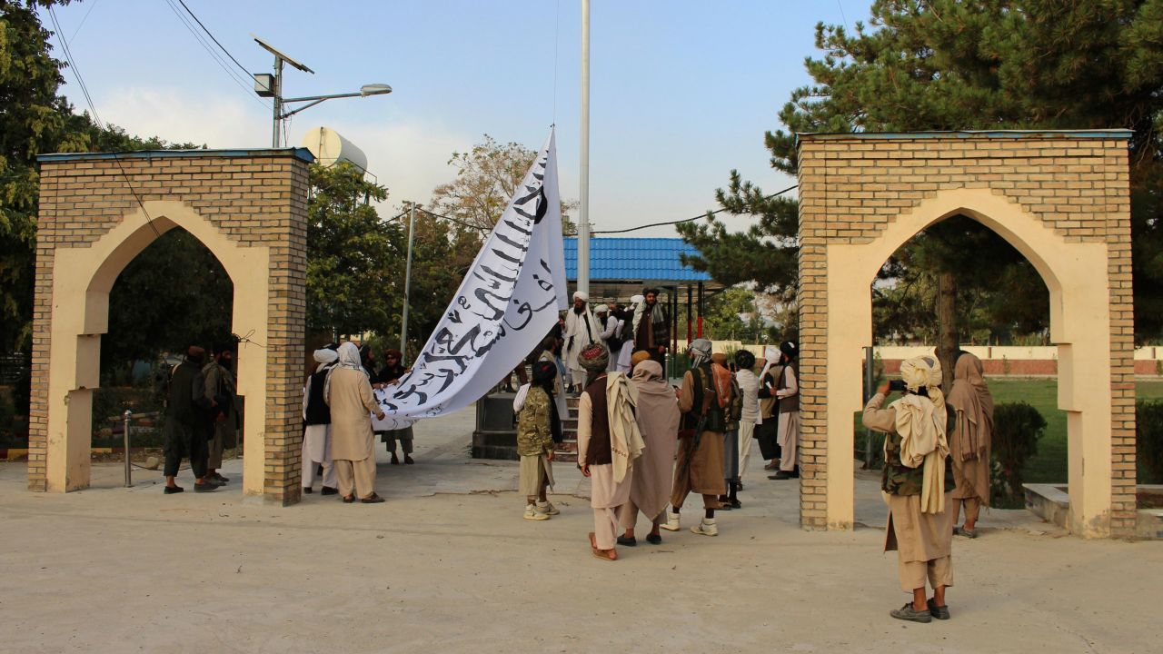 Taliban fighters raise their flag at the provincial governor's house in Ghazni, southeastern Afghanistan, on August 15, 2021.