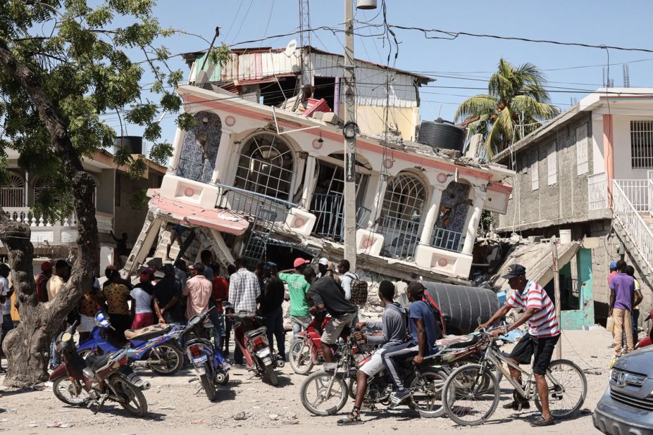 Residents of Les Cayes, Haiti, survey a damaged structure on Sunday, August 15, a day after a 7.2 magnitude earthquake struck the country.