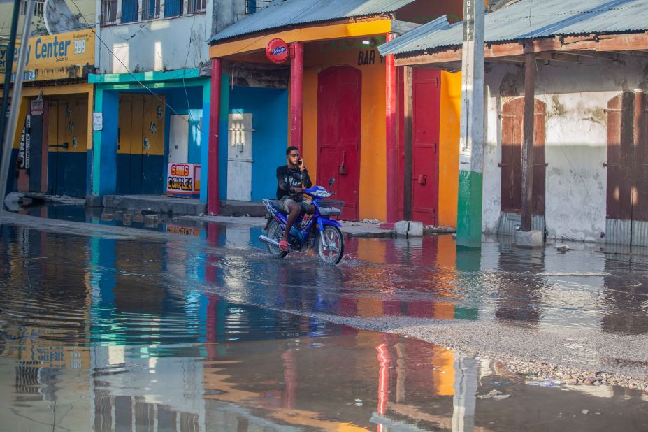 A man rides through water-logged streets in Les Cayes on August 15.